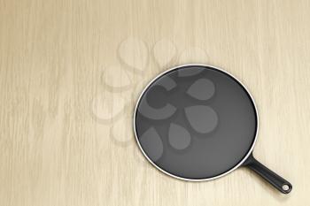 Empty pancake pan on wooden table, top view