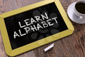 Learn Alphabet Handwritten on Yellow Chalkboard. Business Concept. Composition with Chalkboard and Cup of Coffee. Top View Image. 3d Render.