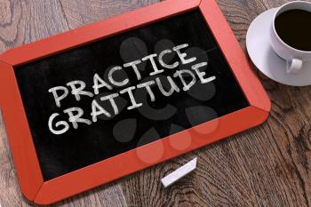 Practice Gratitude Handwritten on Red Chalkboard. Business Concept. Composition with Chalkboard and Cup of Coffee. Top View Image. 3d Render.