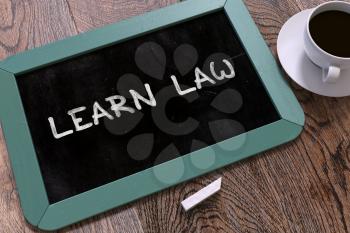 Learn Law Handwritten on Blue Chalkboard. Business Concept. Composition with Chalkboard and Cup of Coffee. Top View Image. 3D Render.