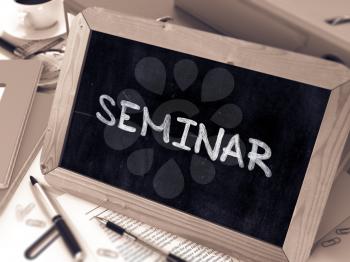 Seminar Handwritten by White Chalk on a Blackboard. Composition with Small Chalkboard on Background of Working Table with Office Folders, Stationery, Reports. Blurred, Toned Image. 3D Render.