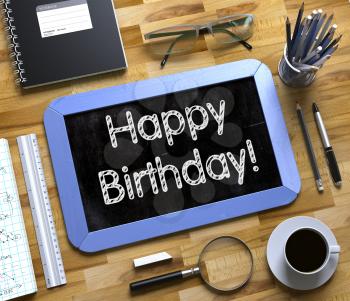 Happy Birthday Handwritten on Blue Small Chalkboard. Top View of Wooden Office Desk with a Lot of Business and Office Supplies on It. Happy Birthday - Text on Small Chalkboard.3d Rendering.