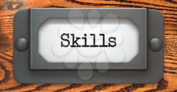 Skills - Inscription on File Drawer Label on a Wooden Background.