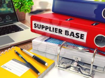 Supplier Base - Red Office Folder on Background of Working Table with Stationery, Laptop and Reports. Business Concept on Blurred Background. Toned Image.