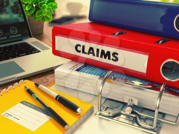 Red Office Folder with Inscription Claims on Office Desktop with Office Supplies and Modern Laptop. Business Concept on Blurred Background. Toned Image.