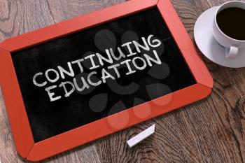 Continuing Education Concept Hand Drawn on Red Chalkboard on Wooden Table. Educational Background. Top View.