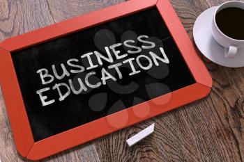 Business Education - Red Chalkboard With Hand Drawn Text and White Cup of Coffee on Wooden Table. Top View.