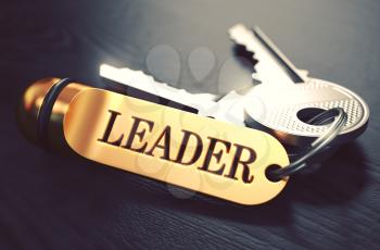 Keys with Word Leader on Golden Label over Black Wooden Background. Closeup View, Selective Focus, 3D Render. Toned Image.