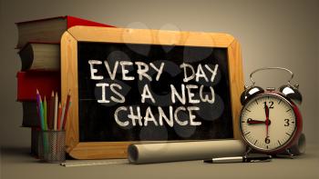 Every Day is a New Chance.  Inspirational Quote Hand Drawn on Chalkboard. Blurred Background. Toned Image.