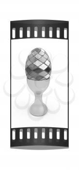 Easter egg on gold egg cups on a white background. The film strip