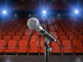 Microphone on the stage of concert hall or theater with red seats and spot light. 3d illustration