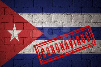 Flag of the Cuba on brick wall texture. stamped of Coronavirus. Corona virus concept. On the verge of a COVID-19 or 2019-nCoV Pandemic. Novel Chinese Coronavirus outbreak