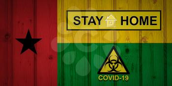 Flag of the Guinea-Bissau in original proportions. Quarantine and isolation - Stay at home. flag with biohazard symbol and inscription COVID-19.