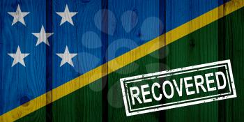 flag of Solomon Islands that survived or recovered from the infections of corona virus epidemic or coronavirus. Grunge flag with stamp Recovered