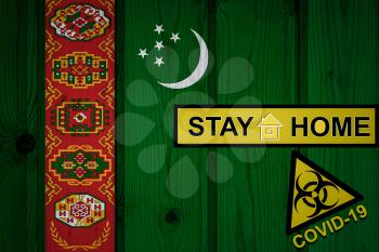 Flag of the Turkmenistan in original proportions. Quarantine and isolation - Stay at home. flag with biohazard symbol and inscription COVID-19.