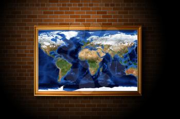 frame with earth map hanging on the brick wall