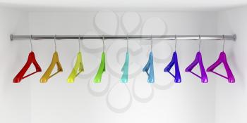 Rainbow colored hangers in the closet