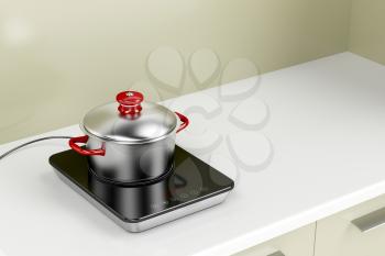 Modern induction cooktop with cooking pot in the kitchen