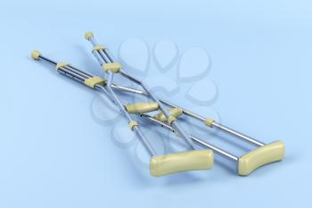 Pair of underarm crutches on blue background 