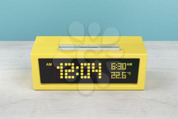 Yellow digital alarm clock on wood nightstand