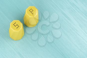 Yellow ceramic salt and pepper shakers on the wood table