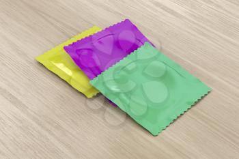 Three different condoms on wooden table 