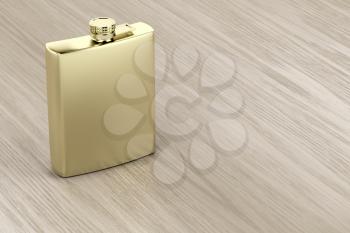 Golden hip flask on wooden table