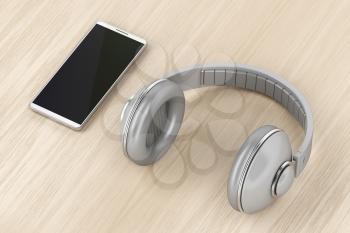 Big wireless headphones and smartphone on wood table 