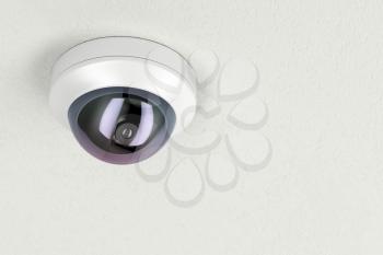 Surveillance camera attached on white ceiling 