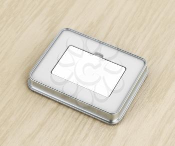 Blank gift card and metal box on wood background

