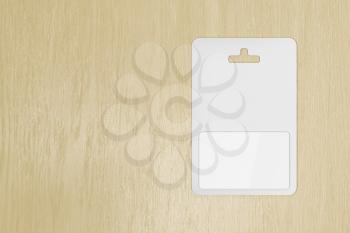Blank gift card in blister packaging on wooden table, top view