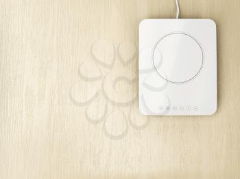 White ceramic or induction cooktop on wood table, top view