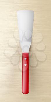 Red spatula on wooden table, top view