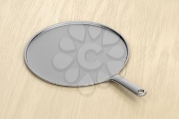 Stainless steel pan on the wooden table