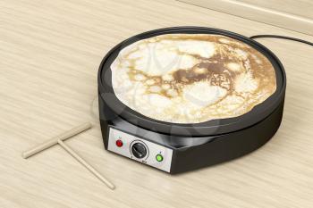Making a pancake with electric pan in the kitchen