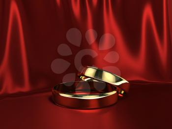 Two gold rings over red silk background