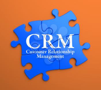 CRM - Customer Relationship Management - Written on Blue Puzzle Pieces on Orange Background. Business Concept.