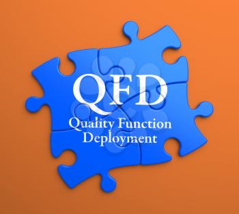 QFD - Quality Function Deployment - Written on Blue Puzzle Pieces on Orange Background. Business Concept.