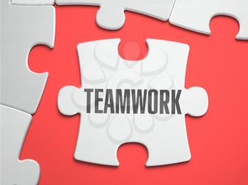 Teamwork - Text on Puzzle on the Place of Missing Pieces. Scarlett Background. Closeup. 3d Illustration.