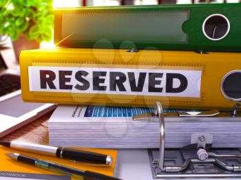 Reserved - Yellow Office Folder on Background of Working Table with Stationery and Laptop. Reserved Business Concept on Blurred Background. Reserved Toned Image. 3D.