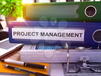 Project Management - Blue Office Folder on Background of Working Table with Stationery and Laptop. Project Management Business Concept on Blurred Background. Project Management Toned Image. 3D.