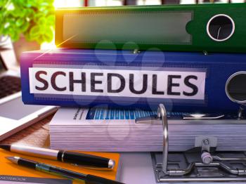 Blue Office Folder with Inscription Schedules on Office Desktop with Office Supplies and Modern Laptop. Schedules Business Concept on Blurred Background. Schedules - Toned Image. 3D.