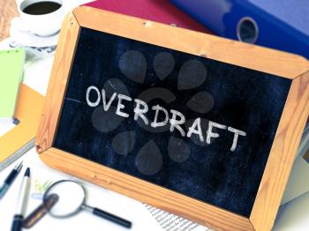 Overdraft - Chalkboard with Hand Drawn Text, Stack of Office Folders, Stationery, Reports on Blurred Background. Toned Image. 3D Render.