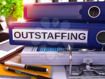 Outstaffing - Blue Ring Binder on Office Desktop with Office Supplies and Modern Laptop. Outstaffing Business Concept on Blurred Background. Outstaffing - Toned Illustration. 3D Render.