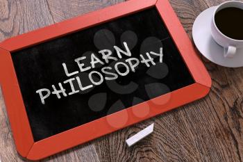 Learn Philosophy Handwritten on Red Chalkboard. Business Concept. Composition with Chalkboard and Cup of Coffee. Top View Image. 3D Render.