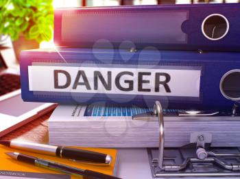 Blue Ring Binder with Inscription Danger on Background of Working Table with Office Supplies and Laptop. Danger - Toned Illustration. Danger Business Concept on Blurred Background. 3D Render.