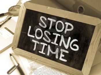 Stop Losing Time Handwritten by White Chalk on a Blackboard. Composition with Small Chalkboard on Background of Working Table with Office Folders, Stationery, Reports. Blurred, Toned Image. 3D Render.
