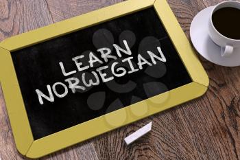 Learn Norwegian Concept Hand Drawn on Yellow Chalkboard on Wooden Table. Business Background. Top View. 3D Render.