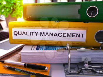 Quality Management - Yellow Office Folder on Background of Working Table with Stationery and Laptop. Quality Management Business Concept on Blurred Background. Quality Management Toned Image. 3D.