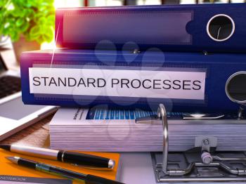 Standard Processes - Blue Ring Binder on Office Desktop with Office Supplies and Modern Laptop. Standard Processes Business Concept on Blurred Background. 3D Render.